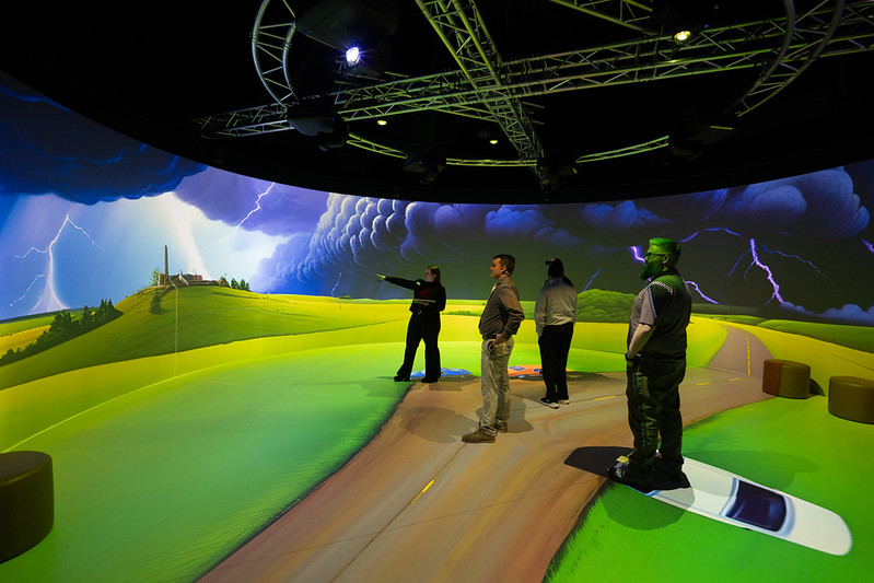 People stood in a VR cylinder looking at a projection of a storm