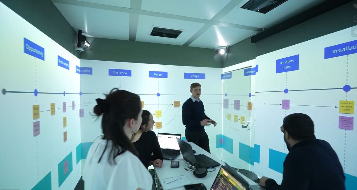 Man in meeting room with several people, using Igloo technology.