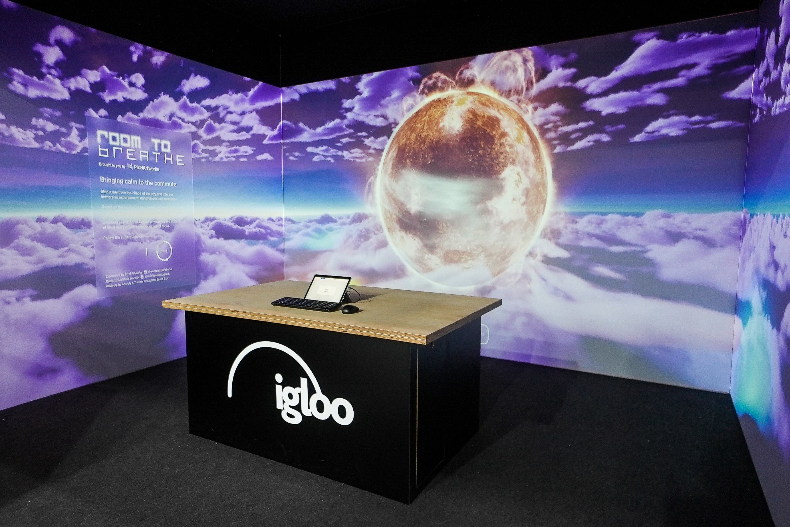 Igloo desk set up with images of the sky on the screens behind a desk