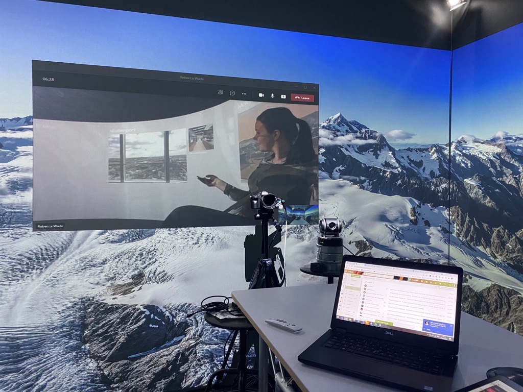 Large Igloo screen with a lady on Zoom, background of mountains.