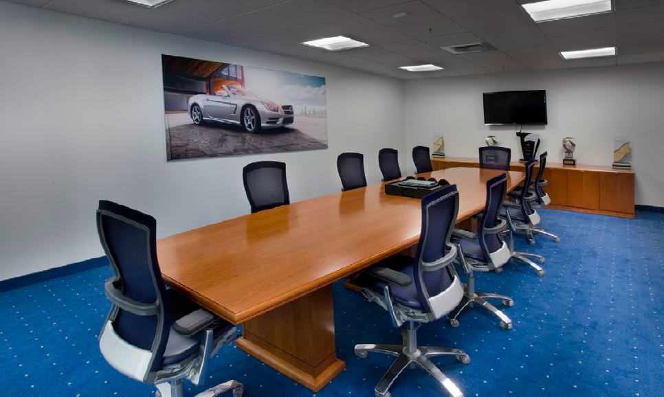 A typical meeting room with a rectangular table and a TV display at one end of the room.