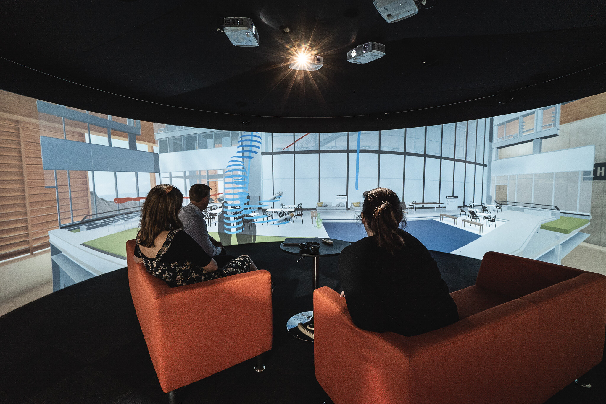 Three people looking at a large scale design on Igloo technology.