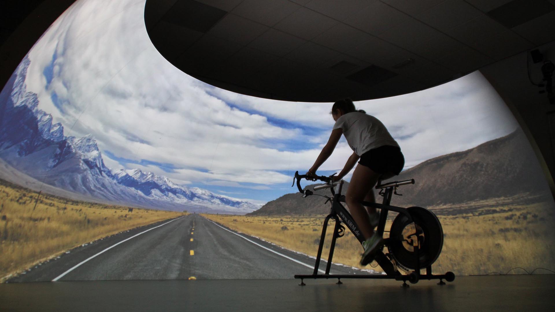 Man riding bike with VR simulation of road at University of Brighton