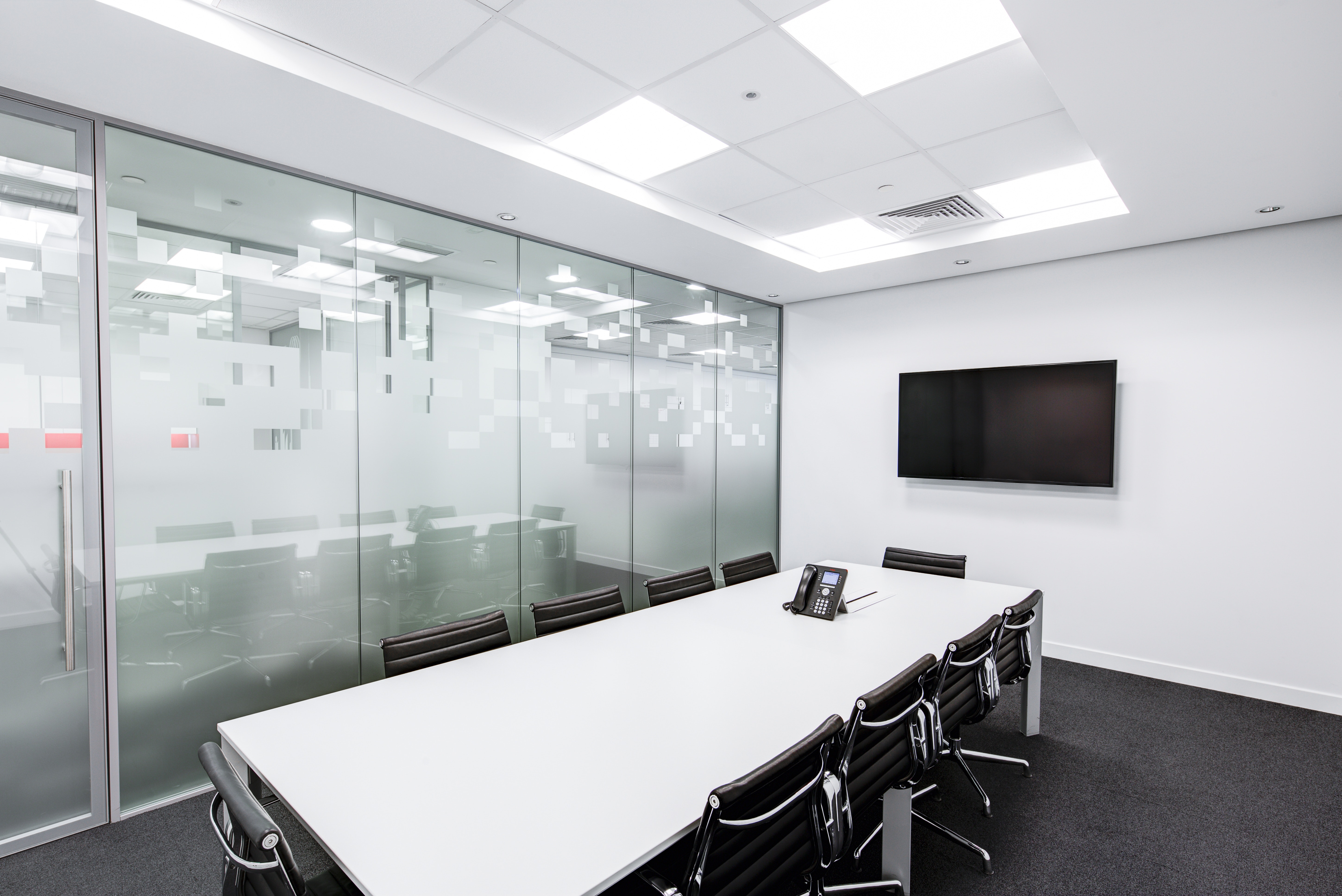 A plain, white, empty office meeting room.